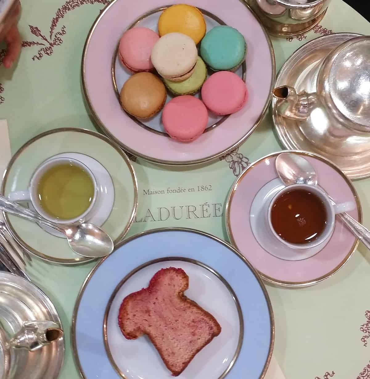 Afternoon tea treats laid out on cute pastel colored tea ware.