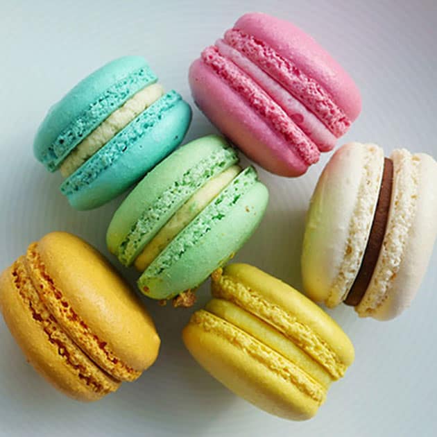 A plate filled with round and smooth macarons with no bumpiness.