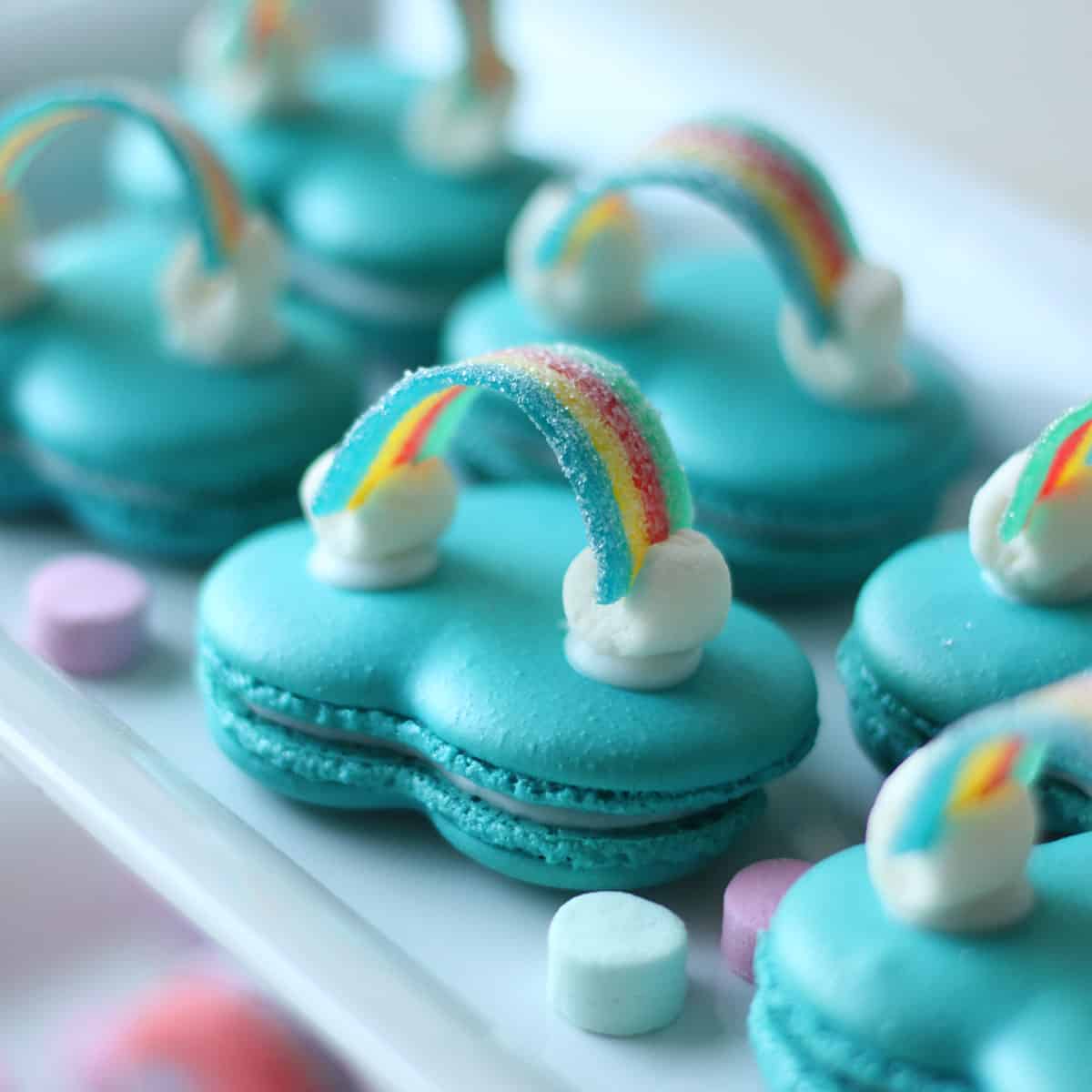 Rainbow cloud macarons on a plate.