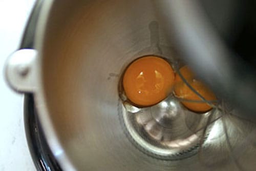Egg yolks in a bowl in the mixer. 