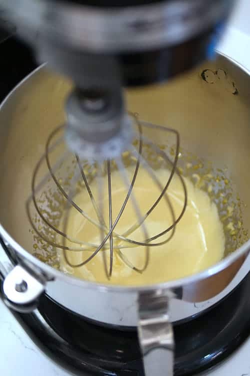Egg yolks looking smooth in a bowl in a mixer. 