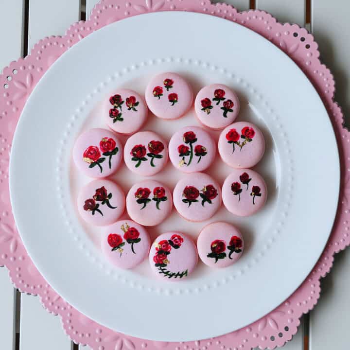 Handpainted macarons filled with duck pate on a plate.