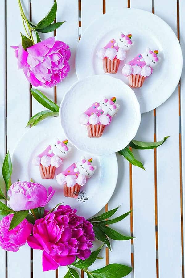unicorn macarons on a plate with flowers.