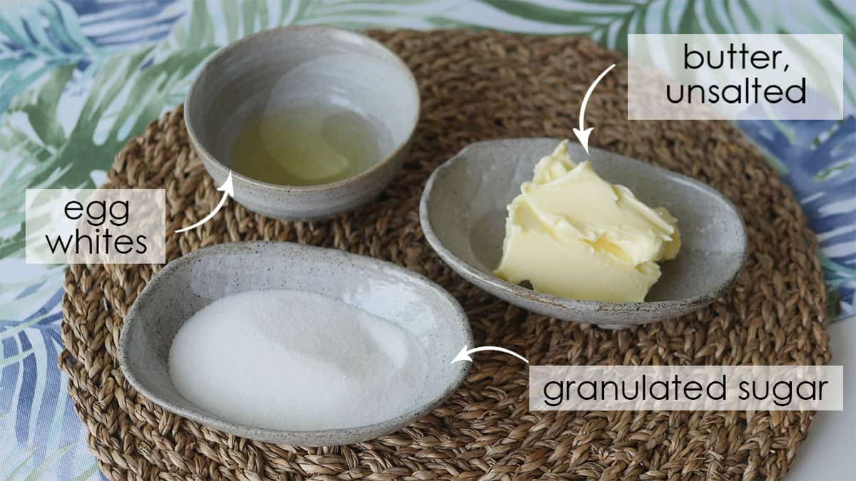 Granulated sugar, butter and egg whites plated on top of a placemat.