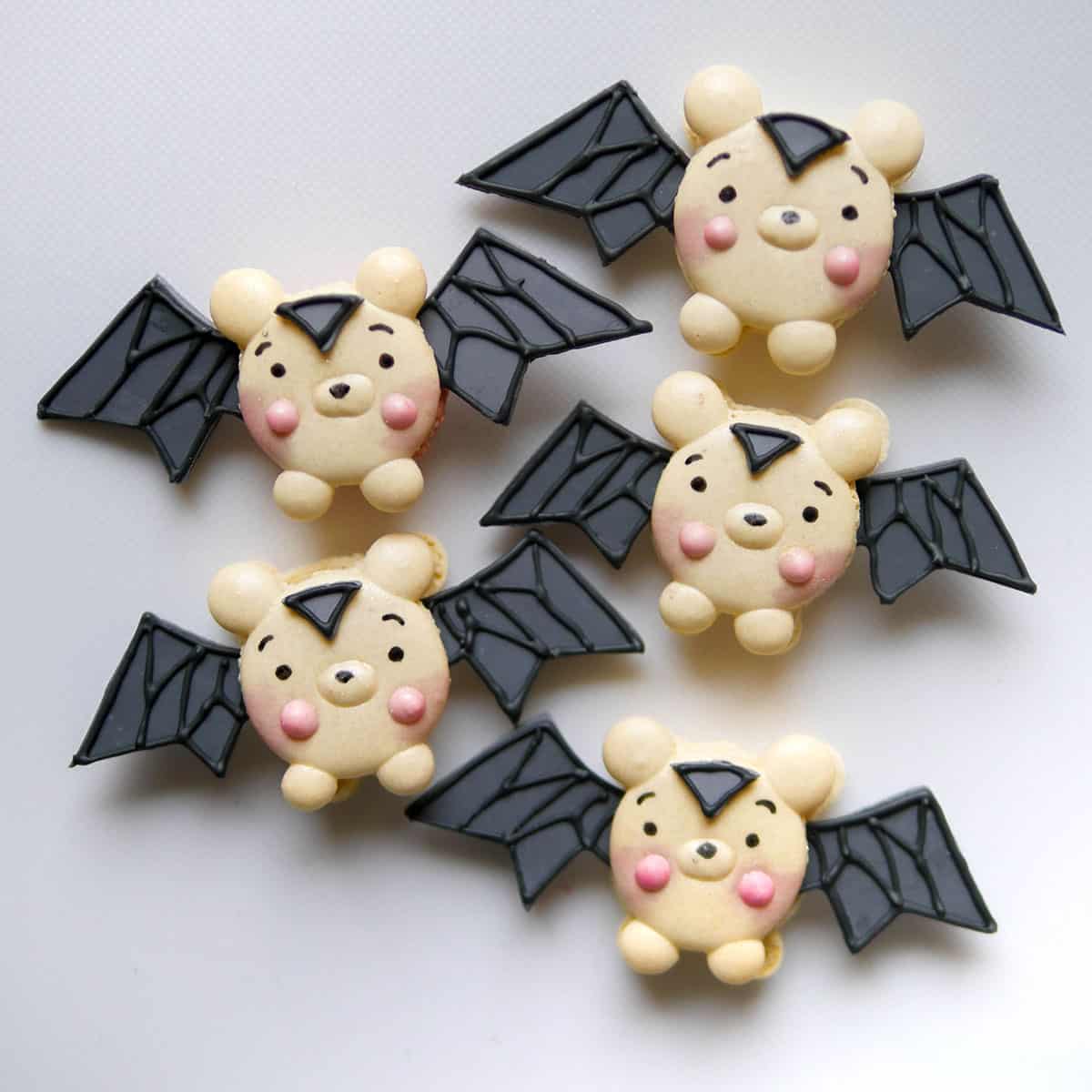 bat macarons with big black wings on a white counter.