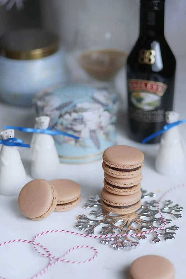 Baileys macarons in a stack styled with mini polar bear figurines and a bottle of Baileys Irish Cream. 