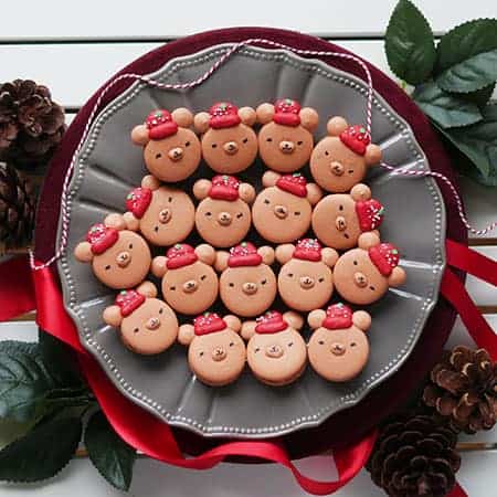 Christmas bear macarons with snow caps on a presentation plate. 