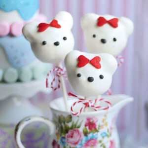 Close up of donut hole cake pop bears propped inside a cup.