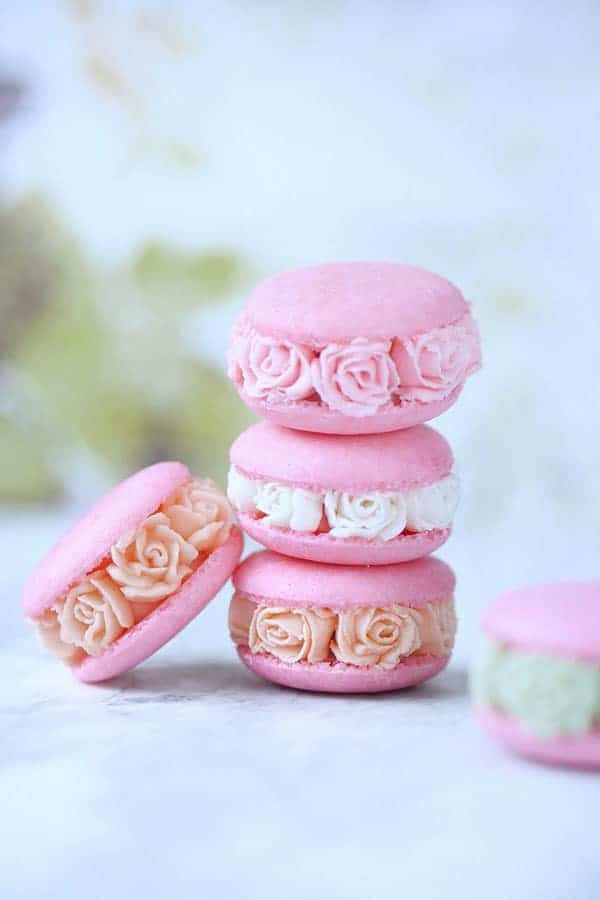A stack of macarons with buttercream piped into blossoms. 