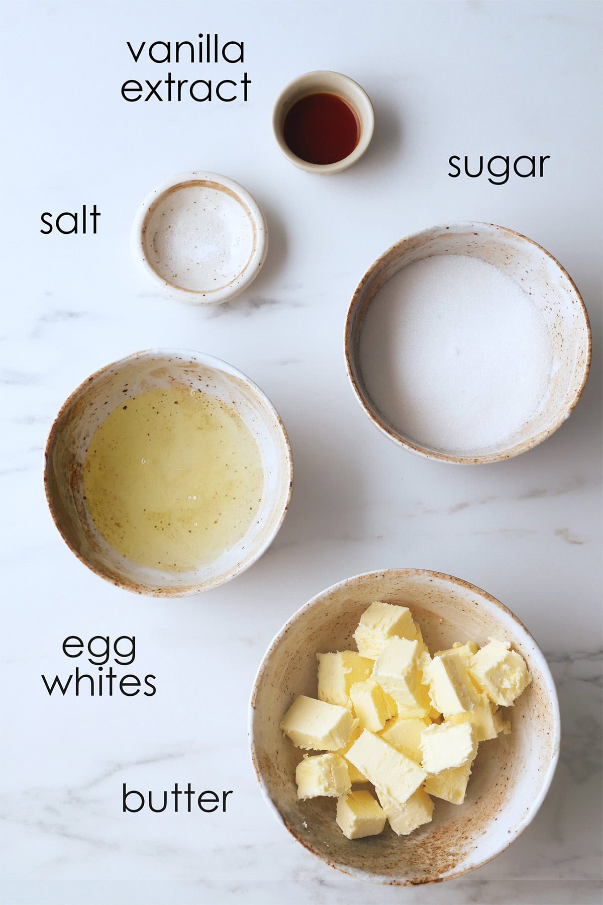 Ingredients for Swiss meringue buttercream laid out on a counter top with ingredient labels.