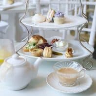 A home-style afternoon tea set served on a 2 tier tea tray in a white farmhouse setting.