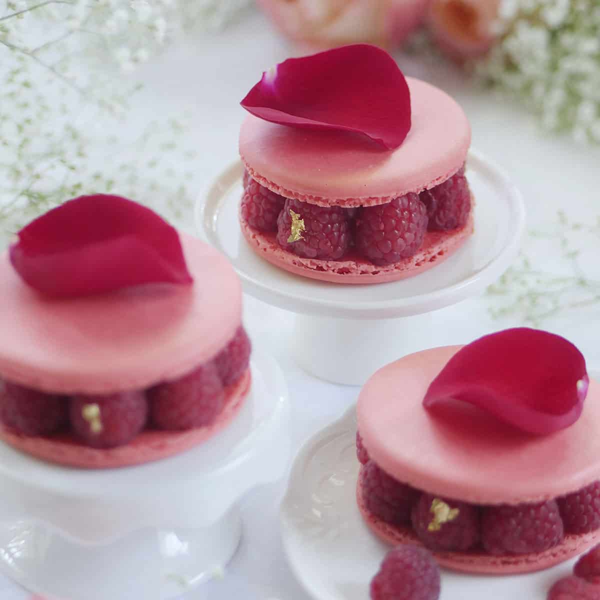 Ispahan macaron cake with fresh raspberries on a little cake stand.