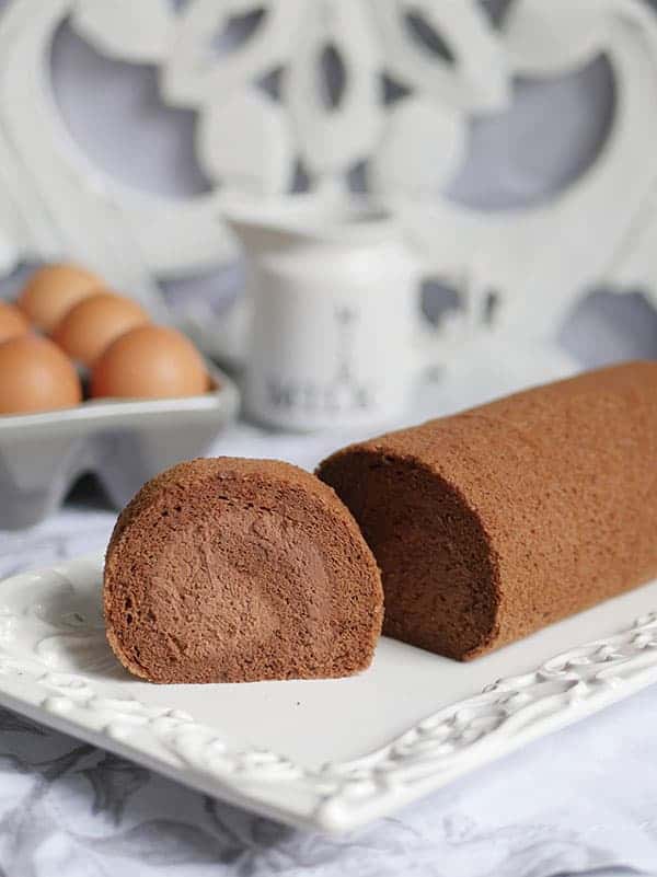 A slice of chocolate cake roll shown from the side. 