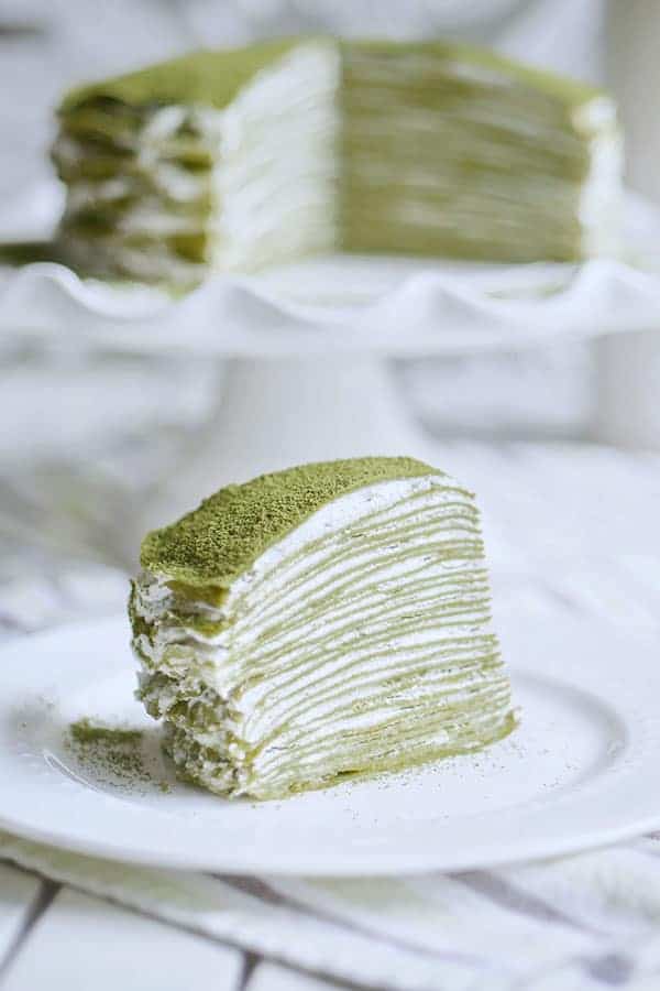 A close-up showing a cross section of a slice of 28 layer matcha mille crepe cake.