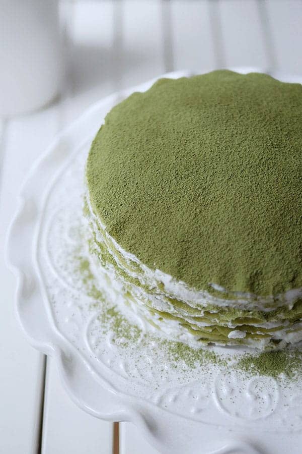 Top of a matcha crepe cake dusted with green tea powder.