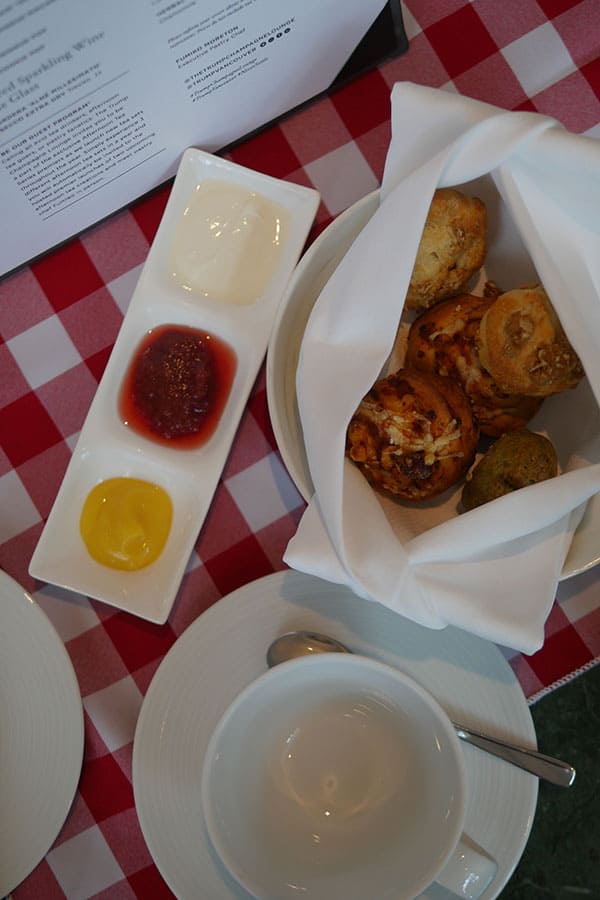 Variety of scones wrapped in a napkin set on top of a plate. 