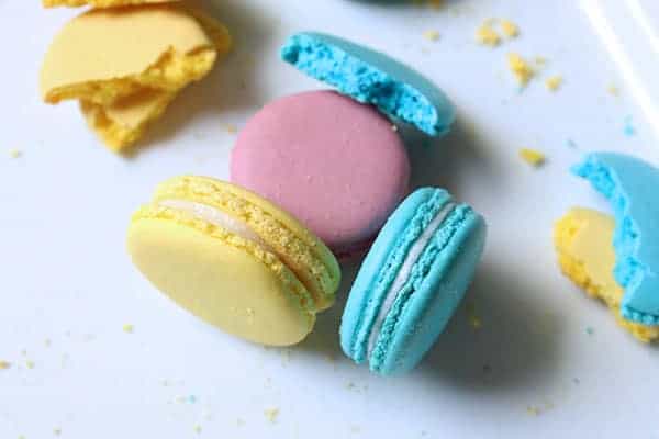 A variety of macarons in different colors laid out onto a plate.