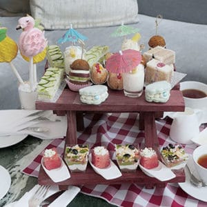 Afternoon tea treats displayed on a picnic bench.