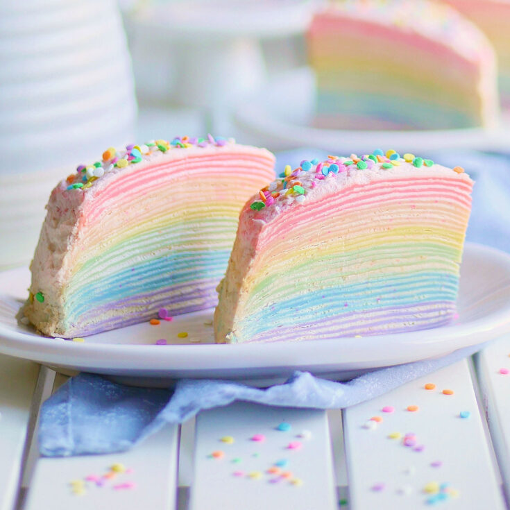 Rainbow Crepe Cake on a small plate with some slices in the back.