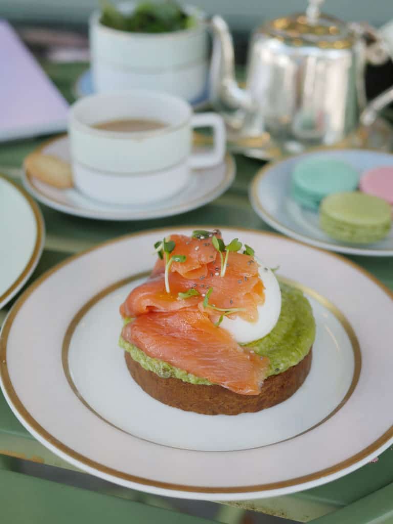 Smoked salmon on top of a brioche with avocado and a poached egg.