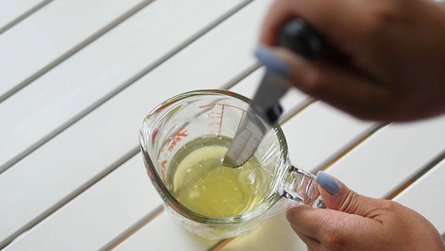 Knife poking hole in a cup filled with aged egg whites.
