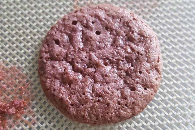 Macaron shell that is porous with little holes on top. 