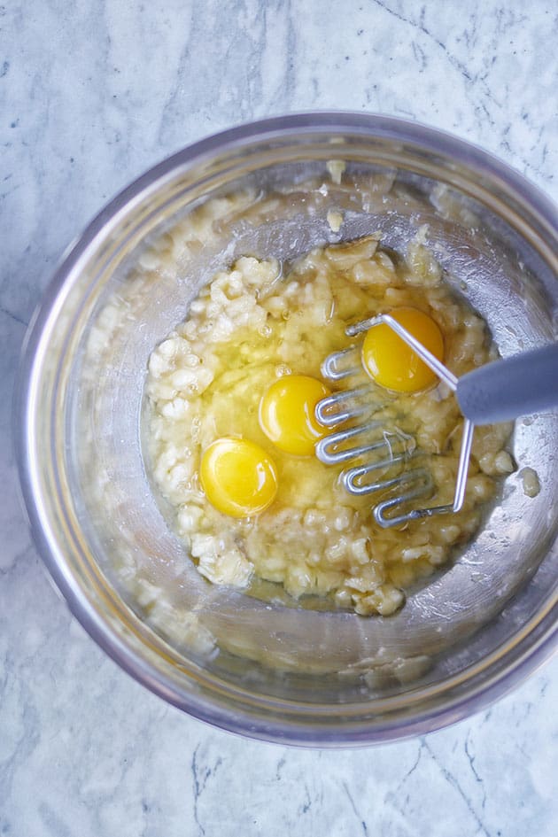 Mashed banana in bowl with eggs. 