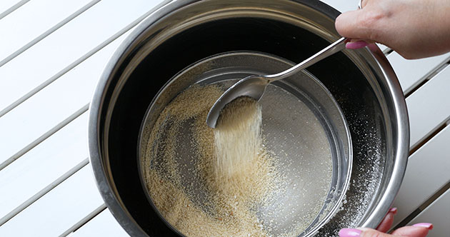 Pushing almond flour through a sieve. 