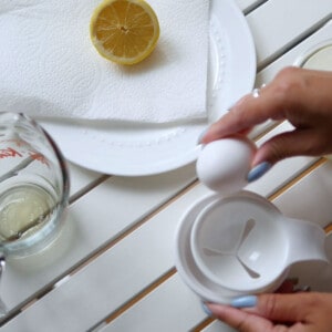 Hand cracking an egg with a separator to age it.