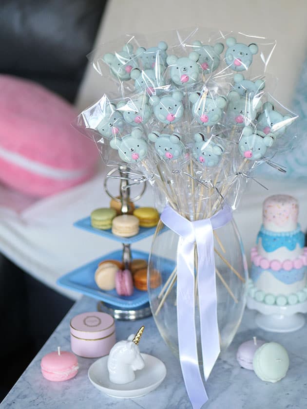 A bouquet of individually wrapped macaron bears on a marble coffee table. 