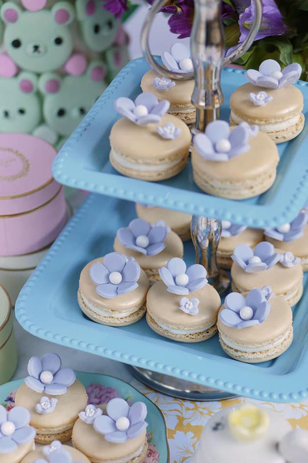 Macarons displayed on a two tier dessert stand. 