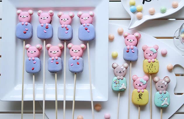 A variety of bear shaped macarons styled against a white plate. 