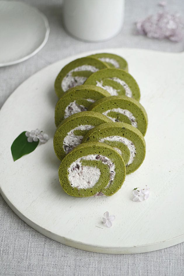 Slices of matcha tea cake roll stacked in a row. 