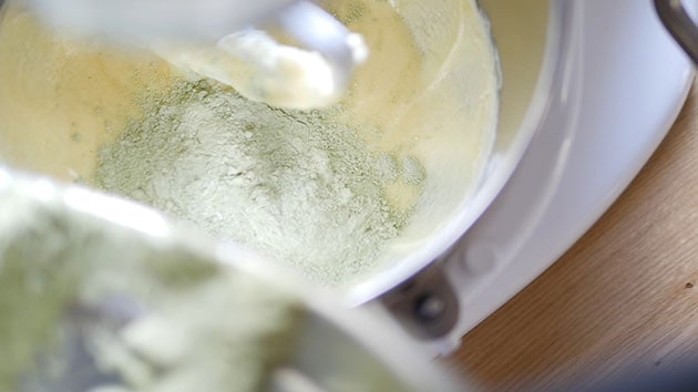 Matcha dry mix being added into the wet batter. 