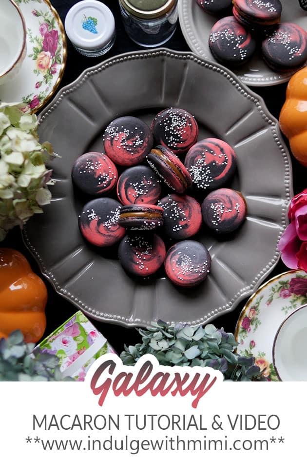 Galaxy macarons on a grey decorative plate.