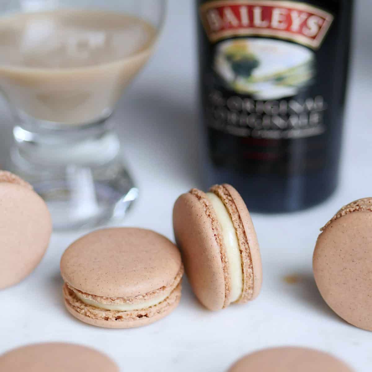 Baileys Irish Cream macarons with a bottle of coffee cream whisky in the back.