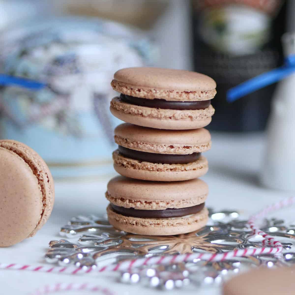 Close up of Baileys Chocolate Irish Cream macarons with a bottle of coffee cream in the back.