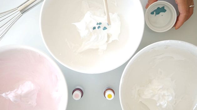 Meringue split up in different bowls with different colors. 