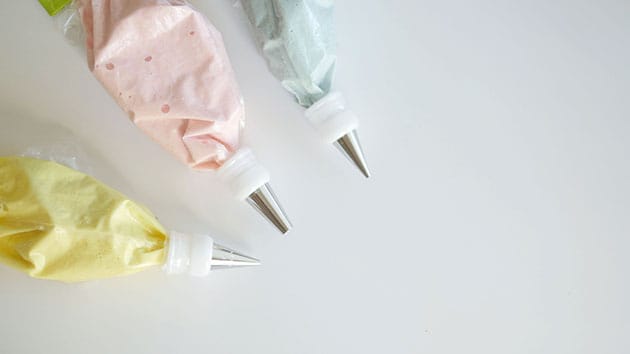 Three different colored macaron batters in a piping bag. 