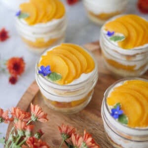 Slices of peach on top of cake in a jar.