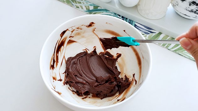 Chocolate ganache filling for macarons held in a bow lhas set and looks thick and pipeable. 