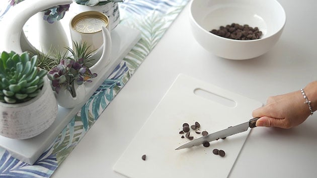 Hand chopping up chocolate for macaron filling. 