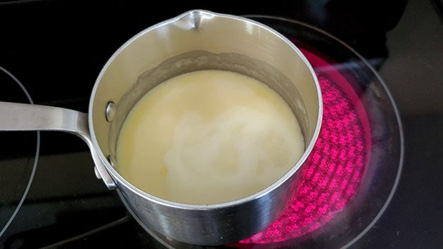 Cream being heated in a small sauce pan. 