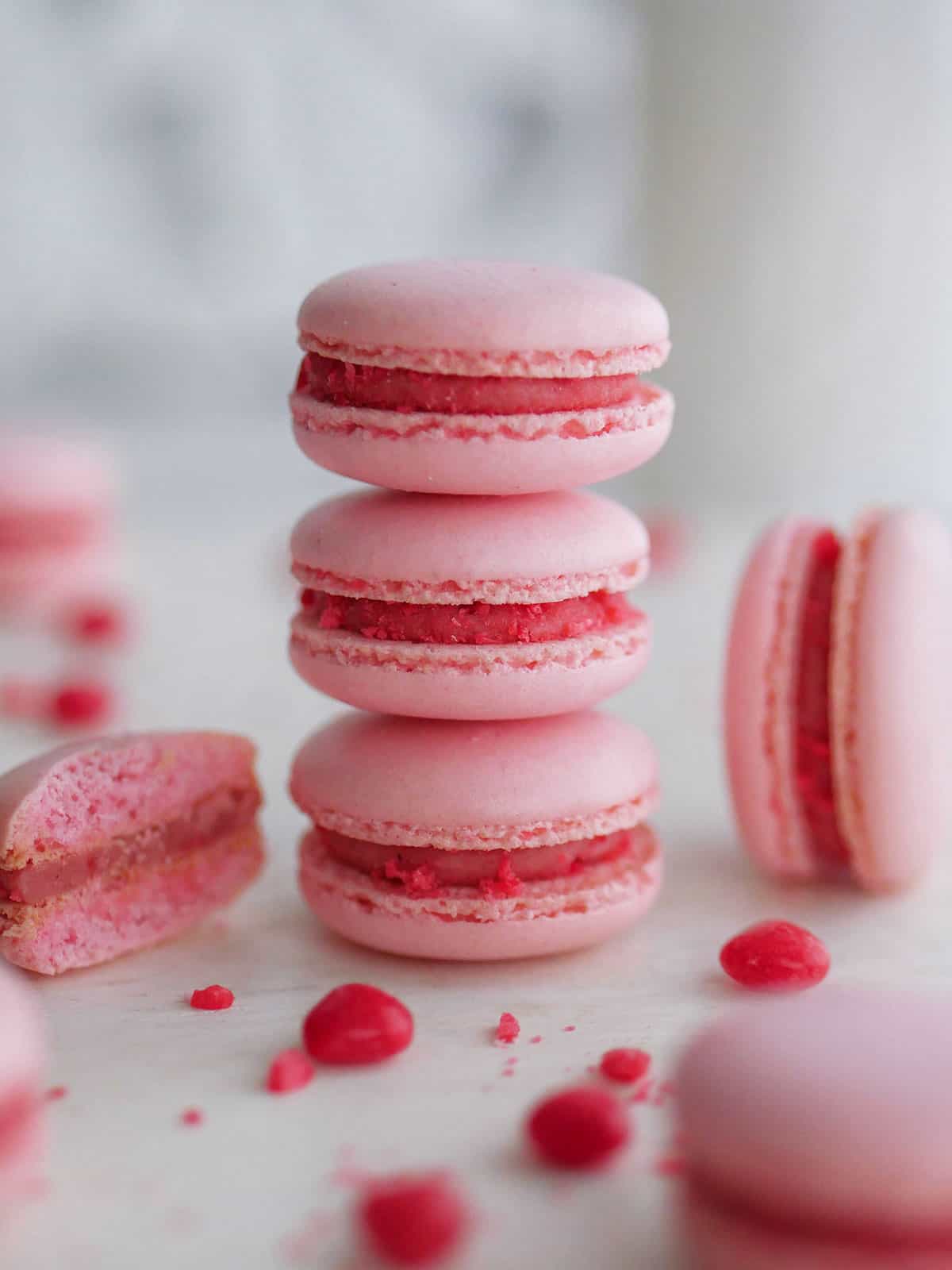 A stack of pink macarons filled with cinnamon candy macaron filling. 
