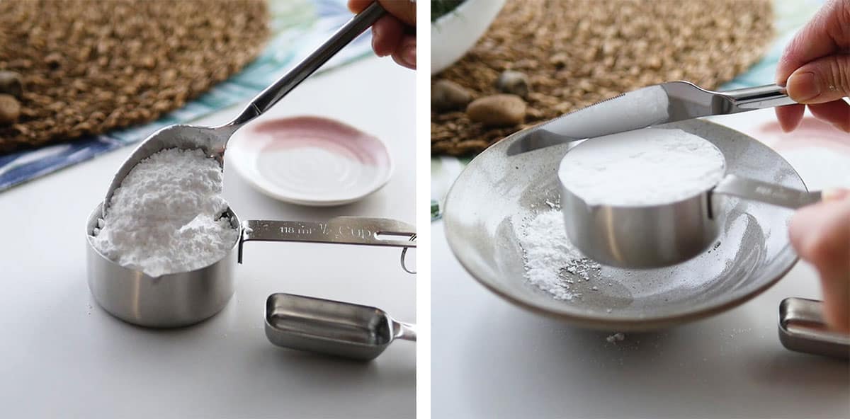 Powdered sugar being poured into a measuring cup and then levelled off with a knife. 