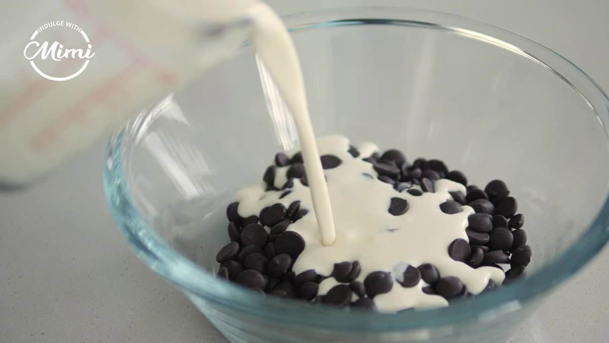 Cream mixed into a clear bowl of chocolate callets