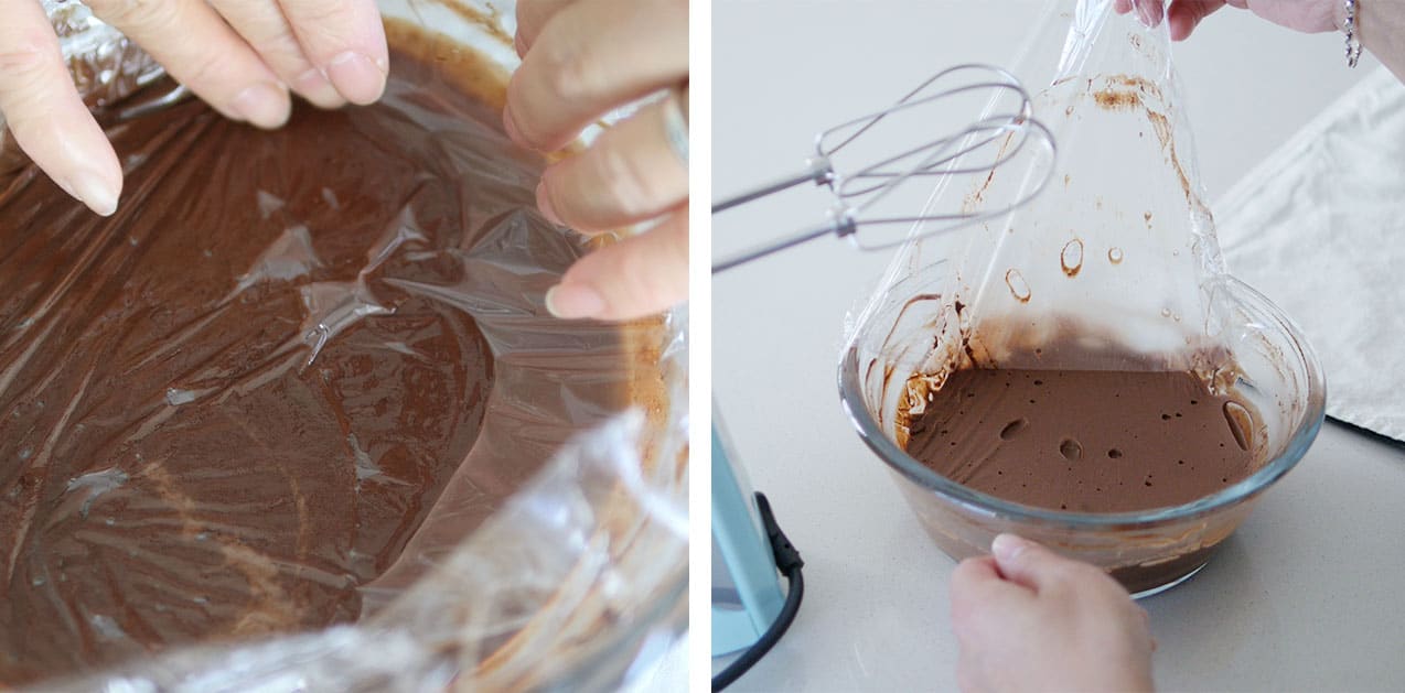 Plastic wrap being removed from the surface of chocolate frosting inside a clear bowl