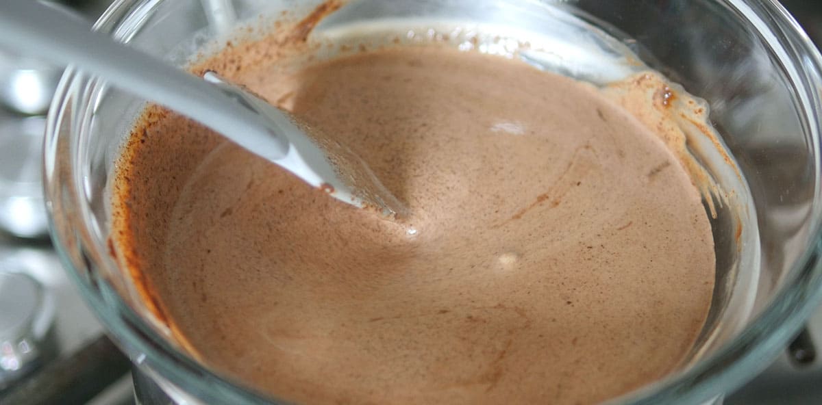 Chocolate cream mix in a bowl over a heated pan on the stove