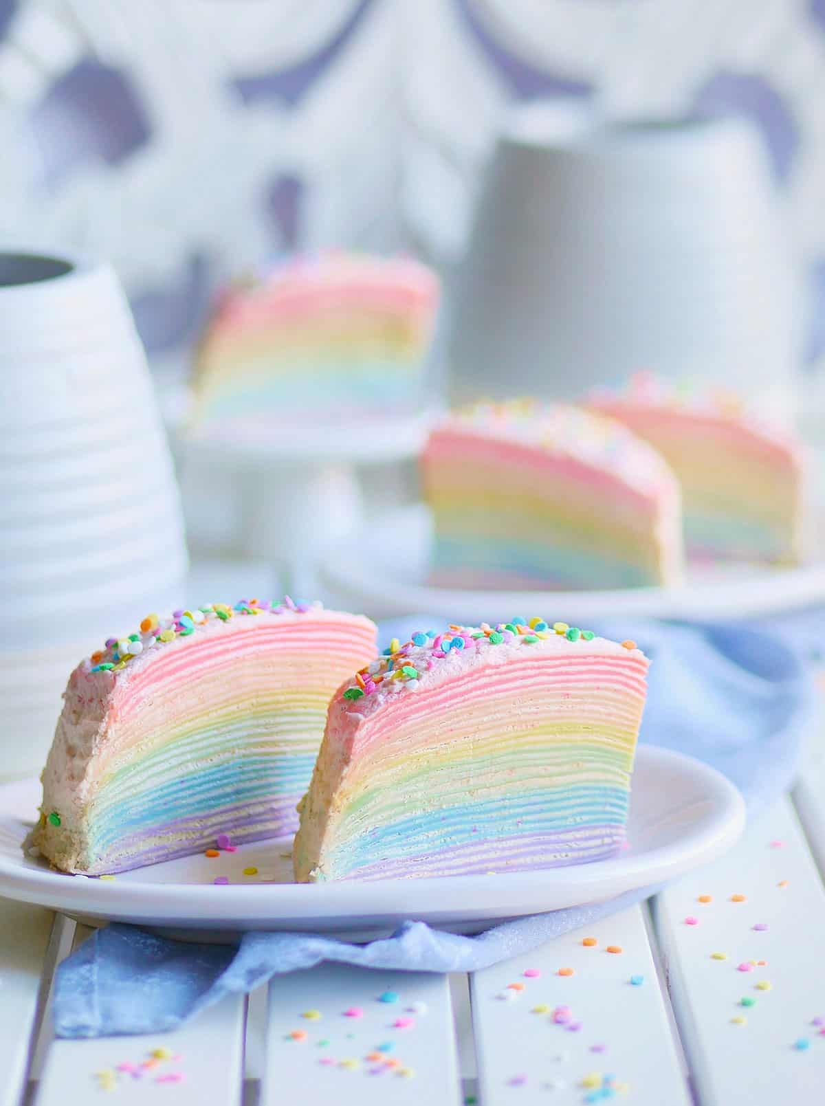 Close-up shot of rainbow mille crepe cake showing all 30-layers of the crepe with a thin layer of cream filling in between. 