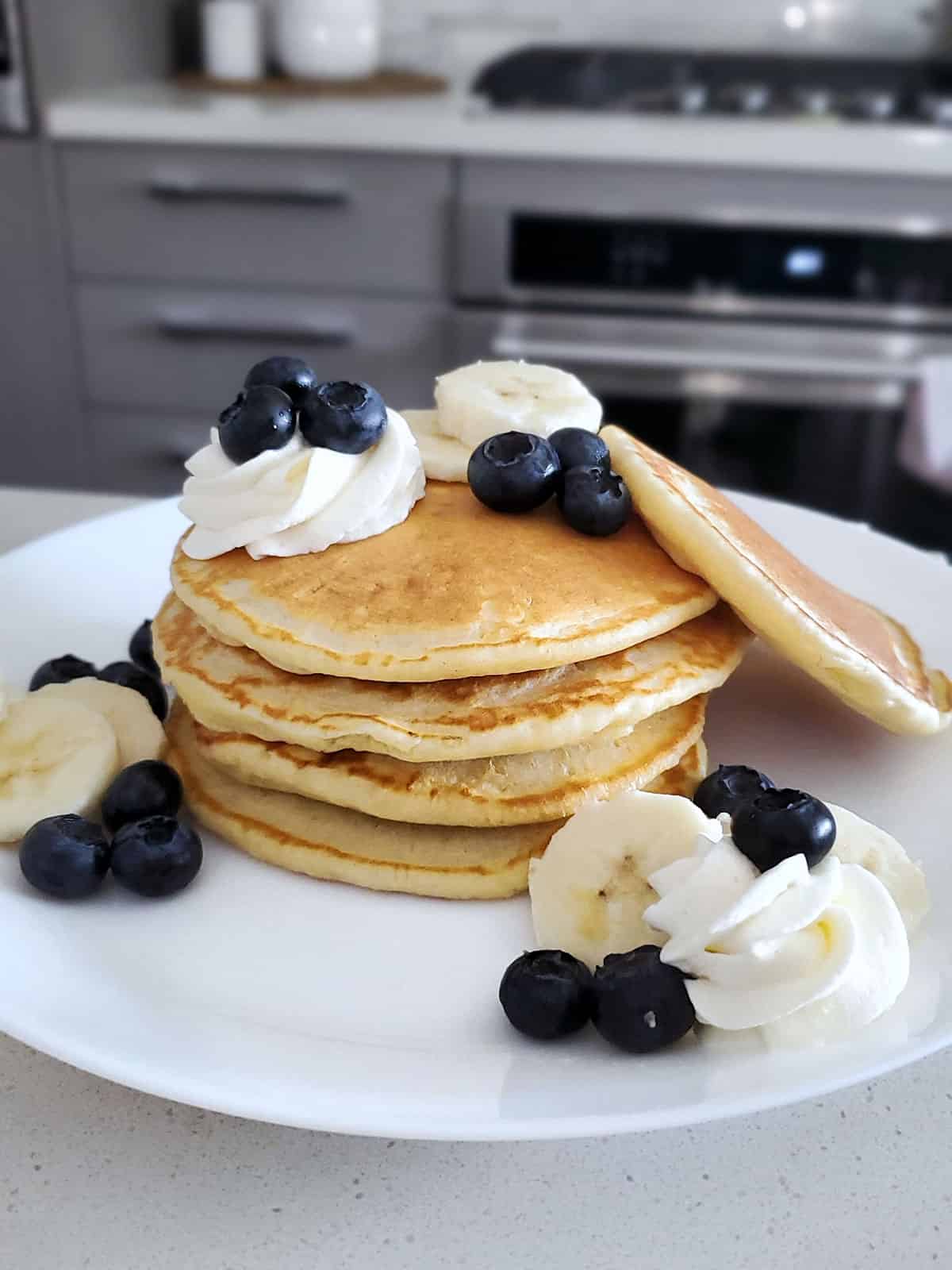 Pancakes topped with blueberries, bananas and mascarpone whipped cream. 